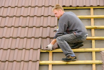 Roof tiles being fitted, pictured on the original T & B website